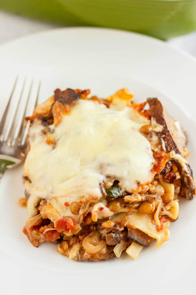 Lentil Lasagna in a Roasted Portobello Cream Sauce with fork on white plate