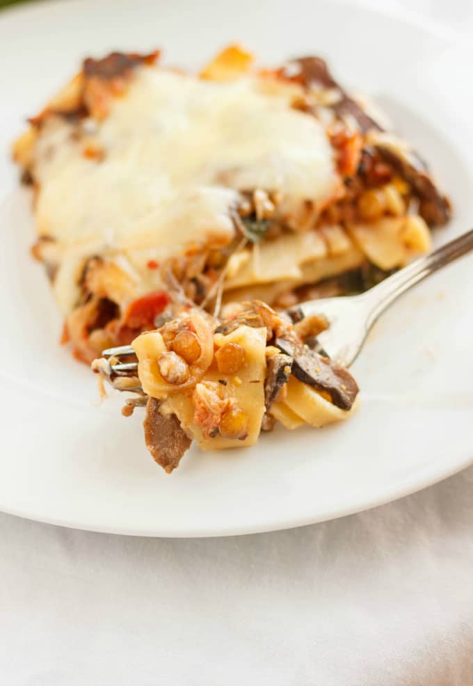 Lentil Lasagna in a Roasted Portobello Cream Sauce picked by fork on white plate