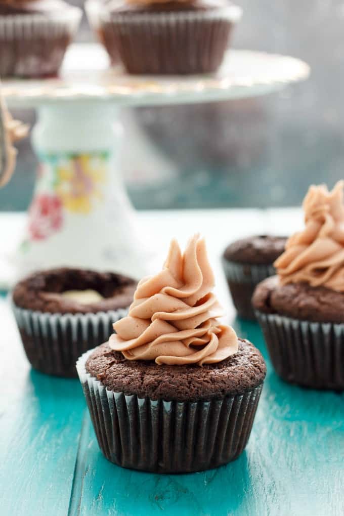 Lindor chocolate cupcakes with chocolate buttercream frosting on blue table