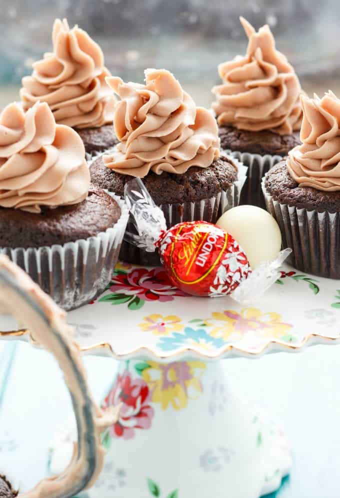 Lindor milk chocolate cupcakes with chocolate buttercream on table with lindor chocolate candy