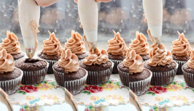 Chocolate cupcakes being frosted by chocolate buttercream