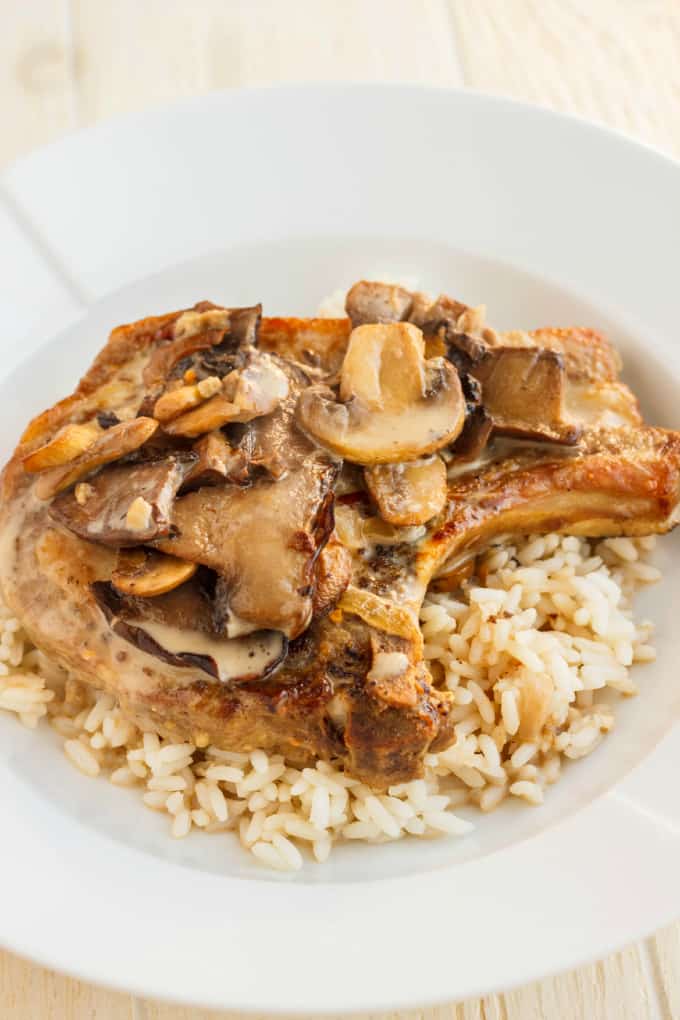 Pork Loin Chops in a Creamy Mushroom Sauce with rice on white plate