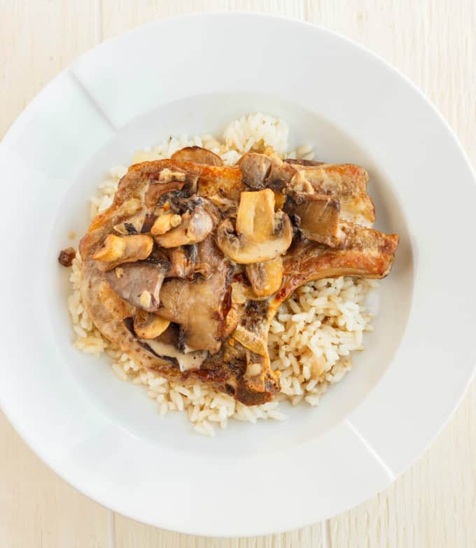 Pork Loin Chops in a Creamy Mushroom Sauce with rice on white plate