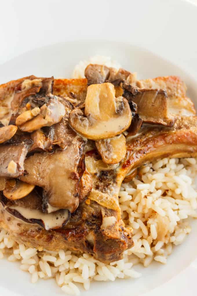 Pork Loin Chops in a Creamy Mushroom Sauce with rice on white plate