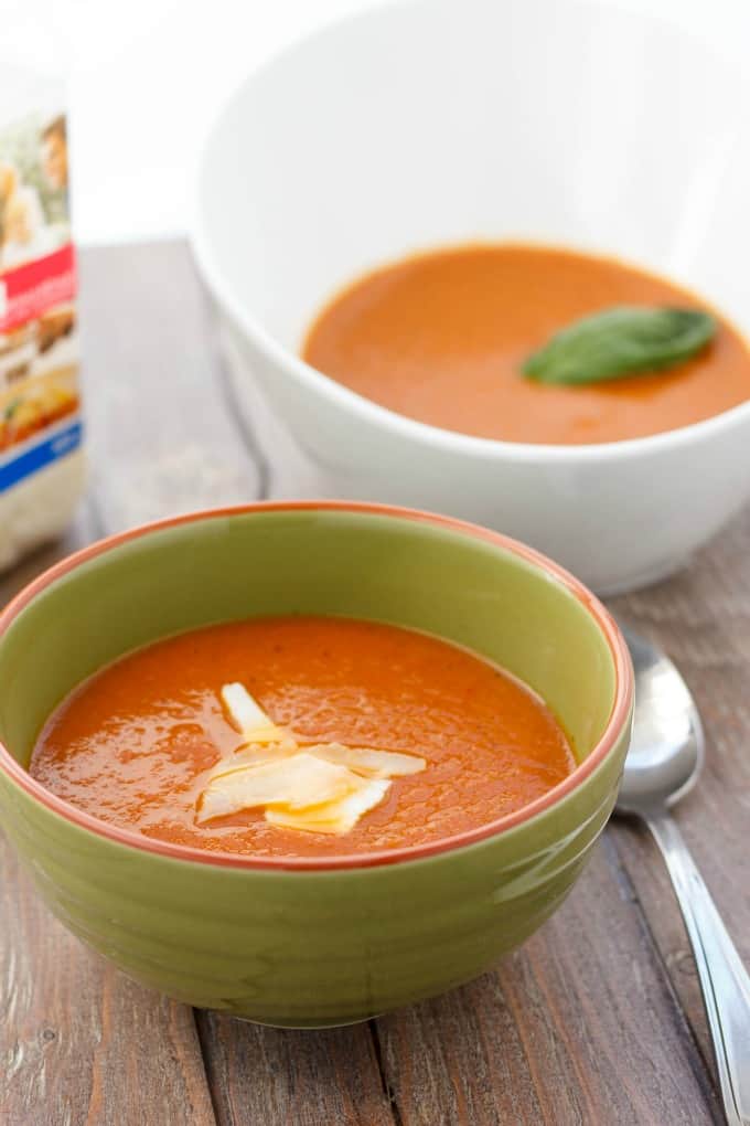 Roasted Tomato and Garlic Soup in white and green bowl on wooden table with spoon#tomato