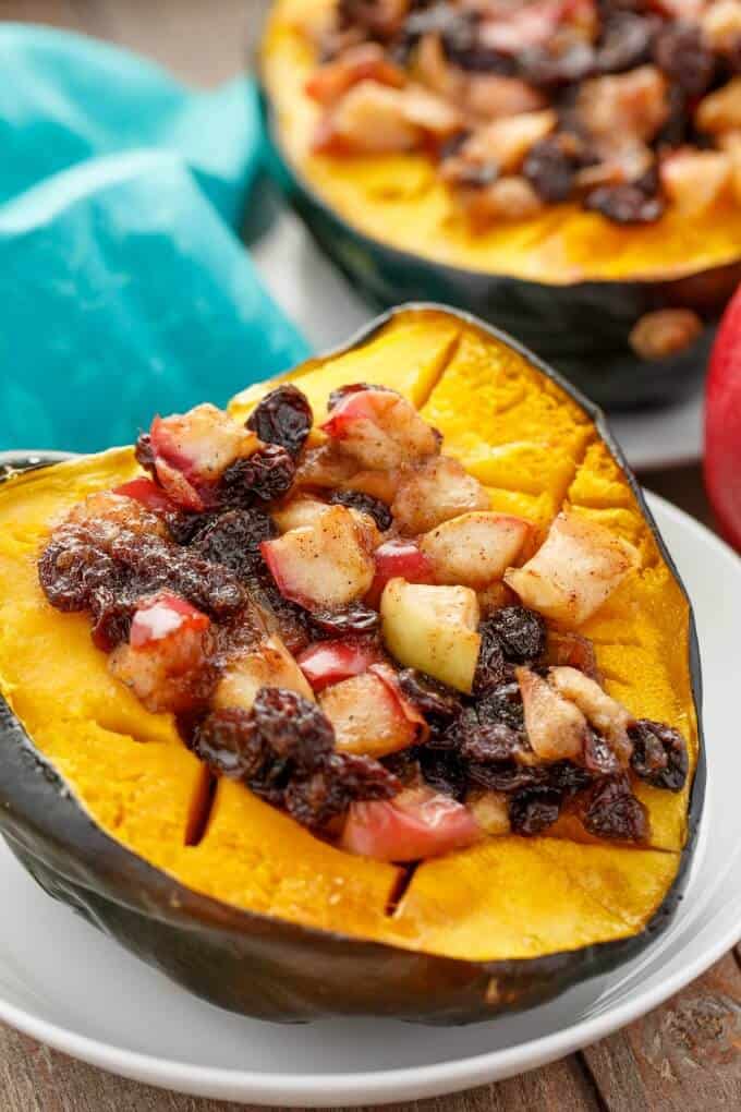 Acorn squash stuffed with apple and raisins squash on white plate