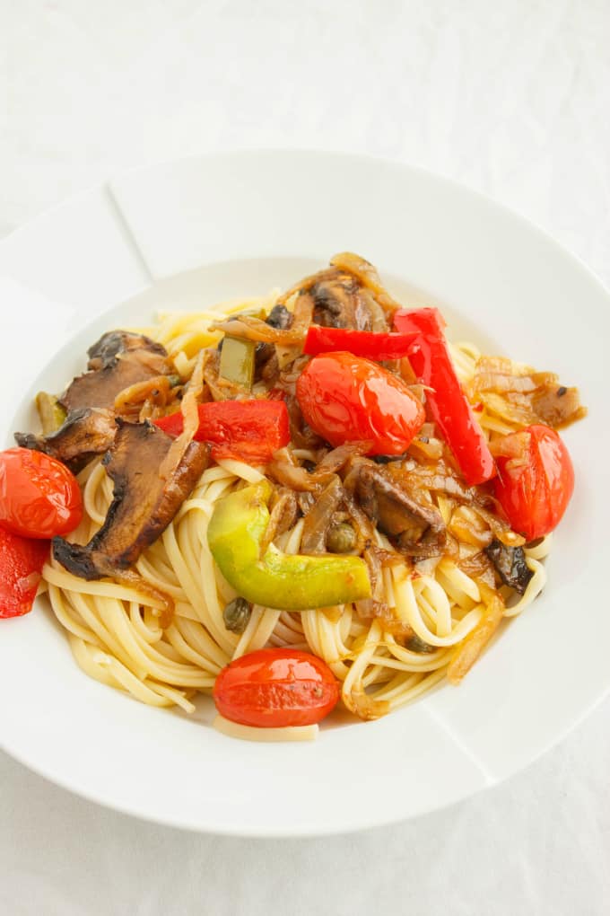 Artichoke Hearts, Caramelized Onions and Roasted Portobello Mushroom Pasta on white plate, white background