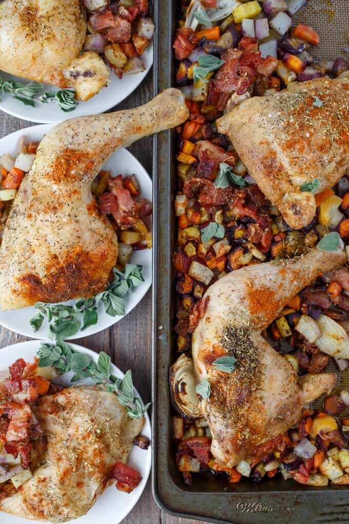 Baked Chicken Leg Quarters with Mixed Vegetables on white plates and baking pot on wooden table