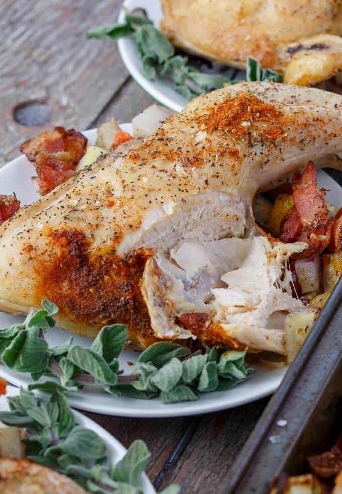 Baked Chicken Leg Quarters with Mixed Vegetables on white table on wooden table