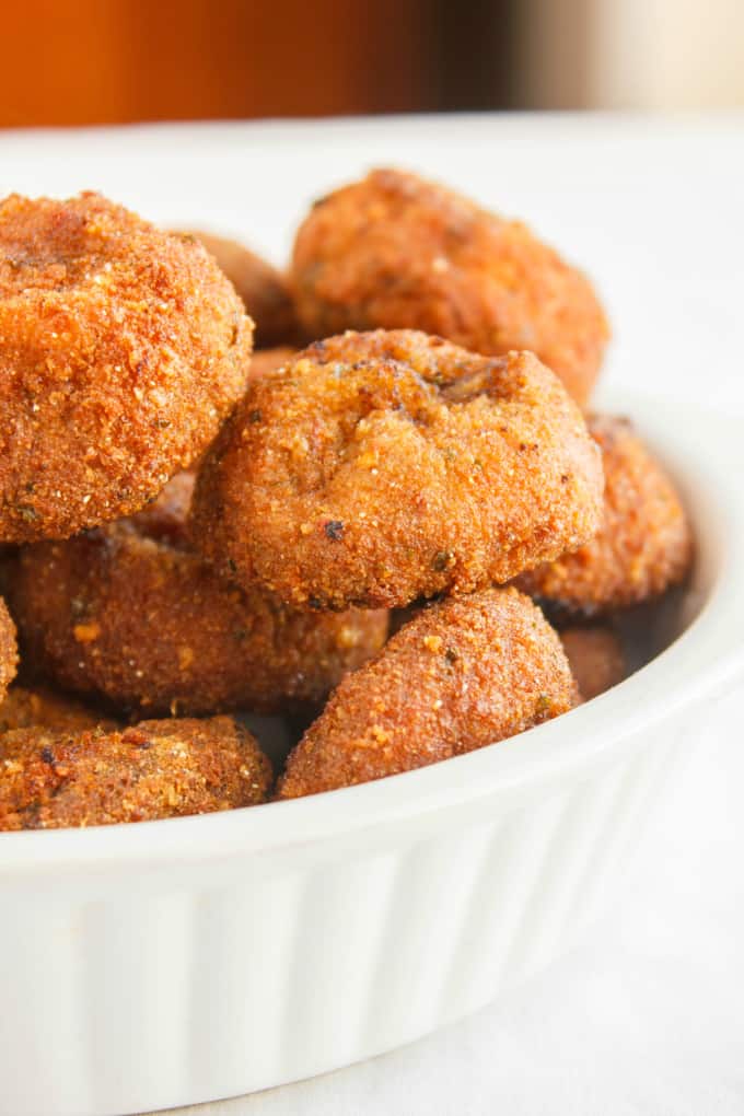 Crispy Deep-Fried Breaded Mushrooms in white bowl on white table