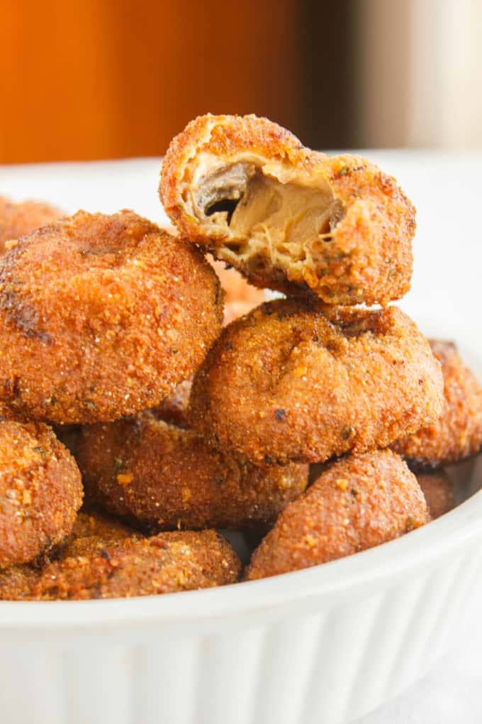 Crispy Deep-Fried Breaded Mushrooms in white bowl on white table