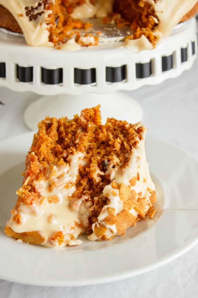 Carrot Cake with a Brown Butter and Brown Sugar Buttercream on white tray and slice of cake on white plate