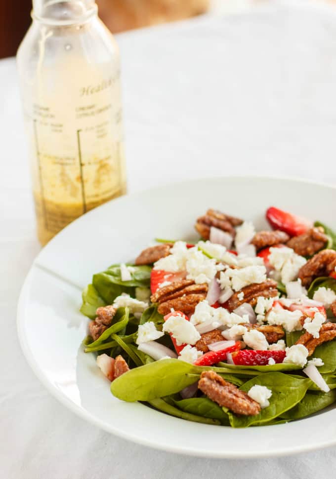 Milestones' California Spring Salad on white plate on white table with plastic bottle