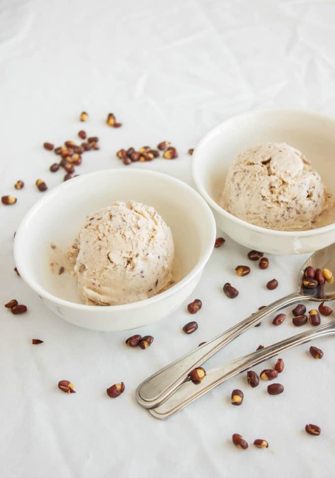 Red Bean Ice Cream in white bowls with spoons, red beans spilled around