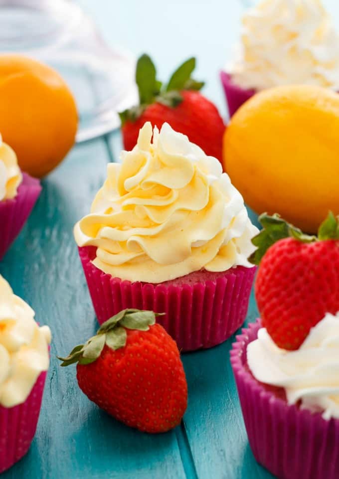 Strawberry Cupcakes with Lemon Swiss Meringue Buttercream on blue table with ripe strawberries and lemons #cupcakes