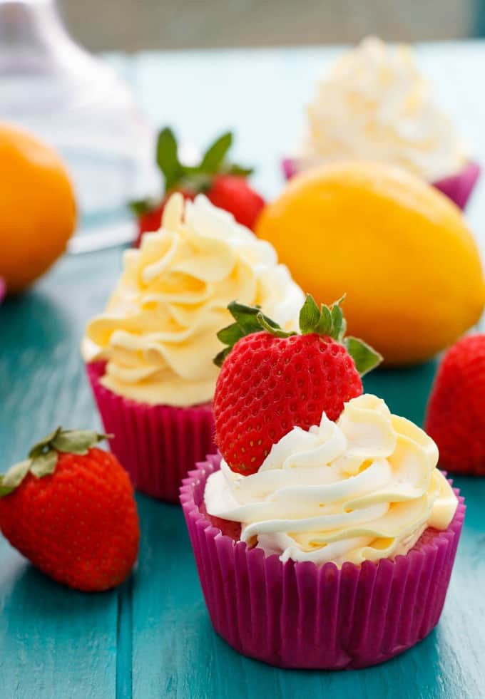 Strawberry Cupcakes with Lemon Swiss Meringue Buttercream  on blue table with ripe strawberries and lemons#lemon