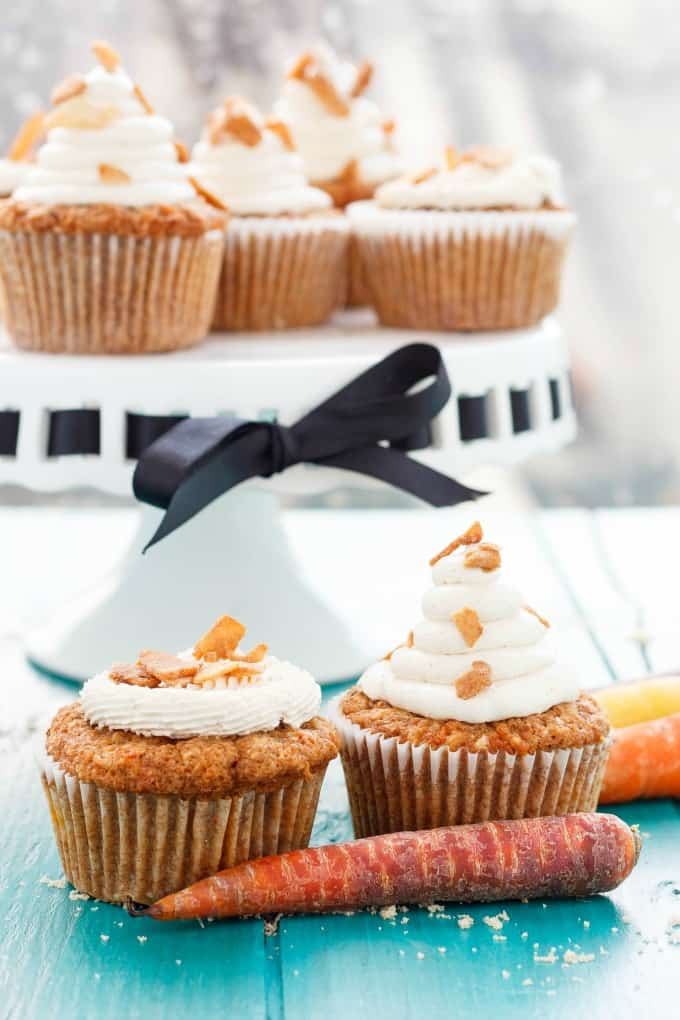 Carrot Cake Cupcakes with Brown Sugar Swiss Meringue Buttercream on white tray, on blue table with carrots#cupcakes