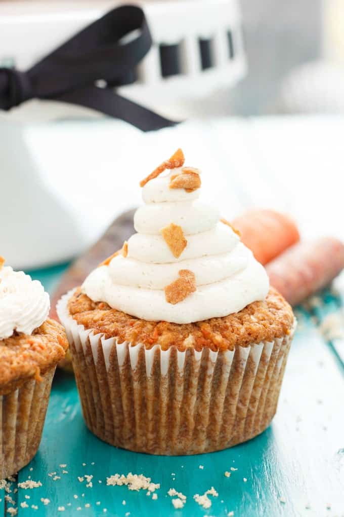 Carrot Cake Cupcakes with Brown Sugar Swiss Meringue Buttercream on blue table with carrots and tray in the background#dessert