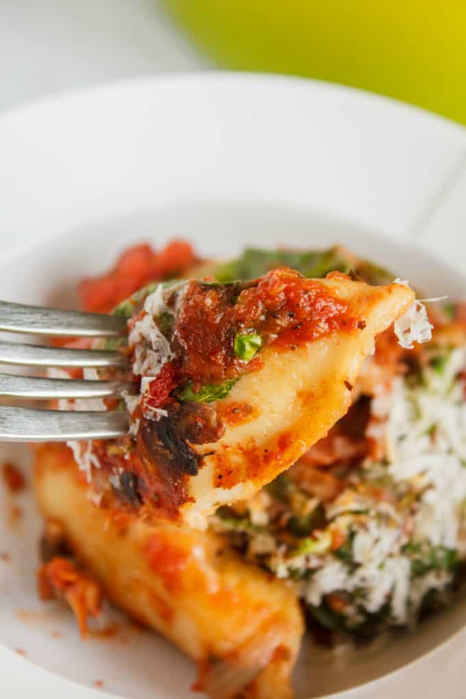 Oven-Baked Perogies in Tomato Sauce on white plate picked by fork