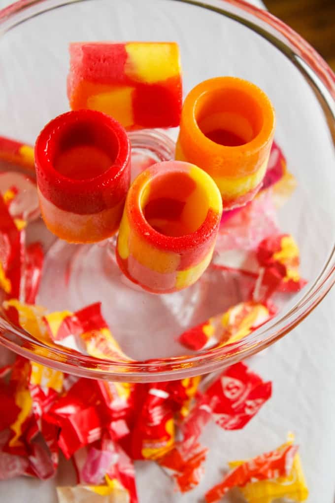 Starburst Candy Shot Glasses on glass tray with empty candy packages under tray