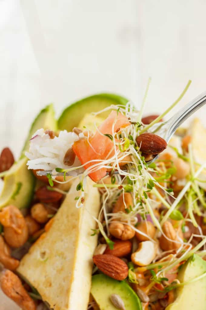 Fresh Powerhouse Bowl picked by fork with veggies, fruits, bread, rice and nuts