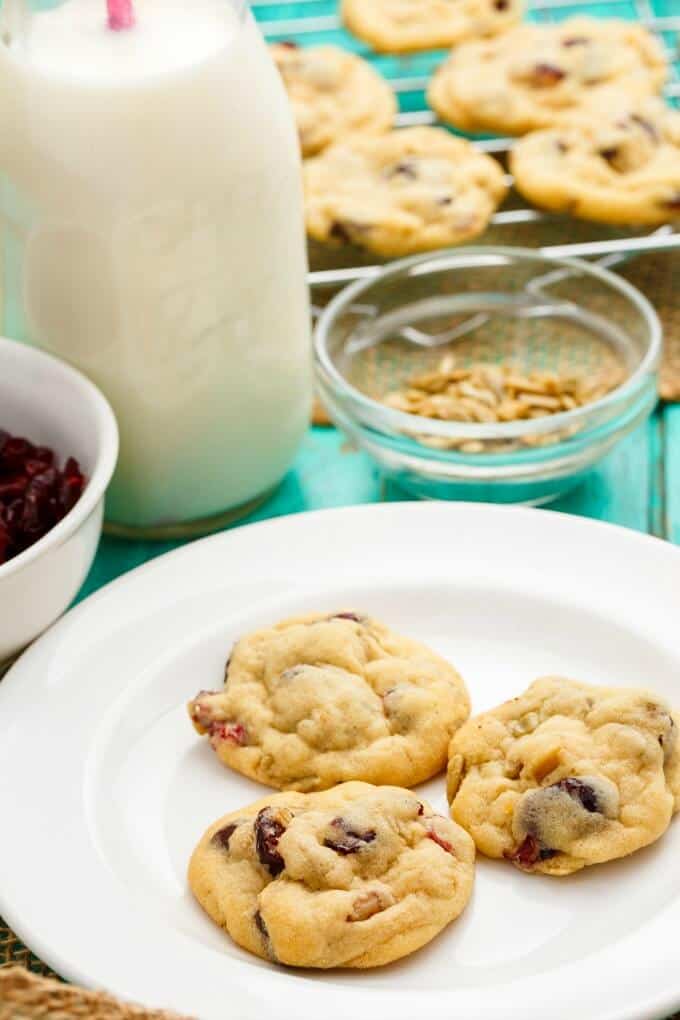 Granola Bar Chocolate Chip Cookies on white plare and cooking grid next to bowls of ingredients with glass jar full of milk