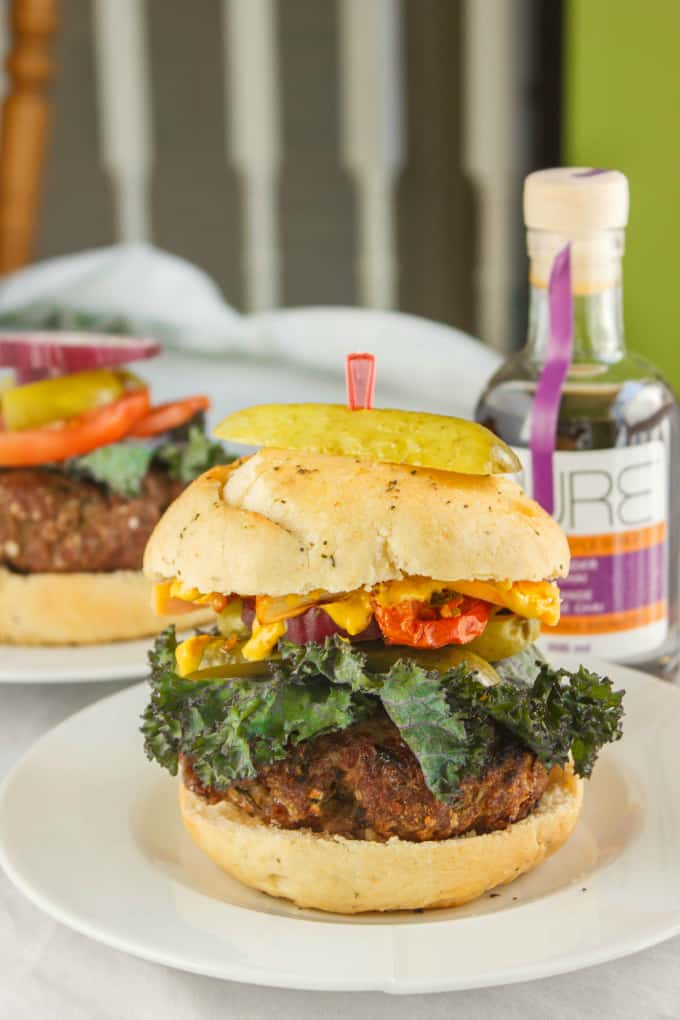 Grill Homemade Hamburger on white plate with bottle and hamburger in the background