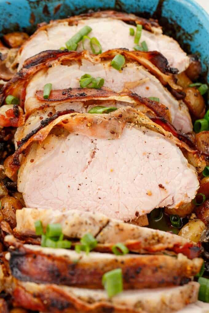 bacon wrapped pork loin sliced with veggies and potatoes