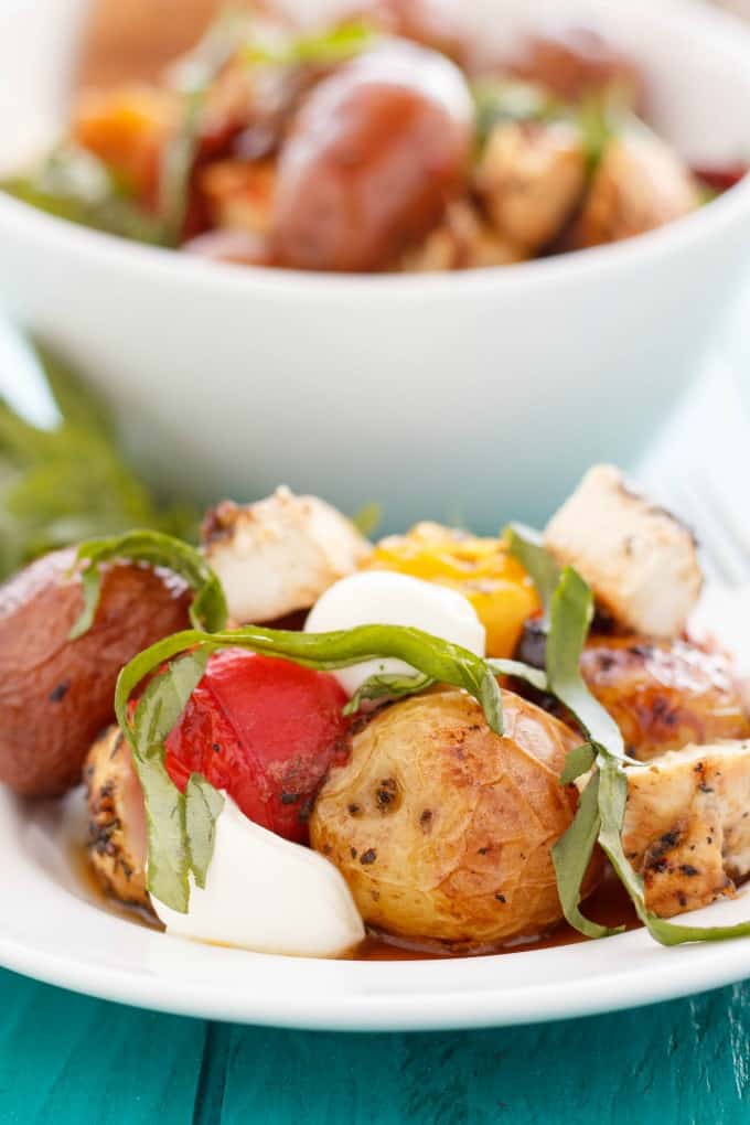 Roasted Potato and Chicken Caprese Salad  on white plate and in white bowl on blue table#salad