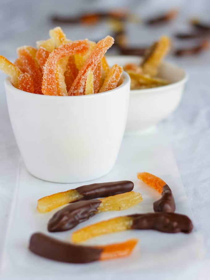 Homemade Candied Citrus Peels in white bowls and on white napkin