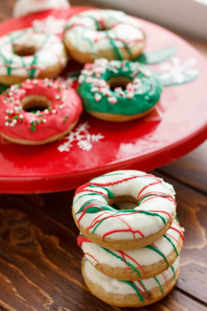 Christmas Doughnuts with Candy Melts Glaze on wooden table and red tray