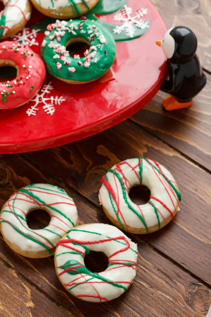 Christmas Doughnuts with Candy Melts Glaze on wooden table and red tray#bakeddoughnuts