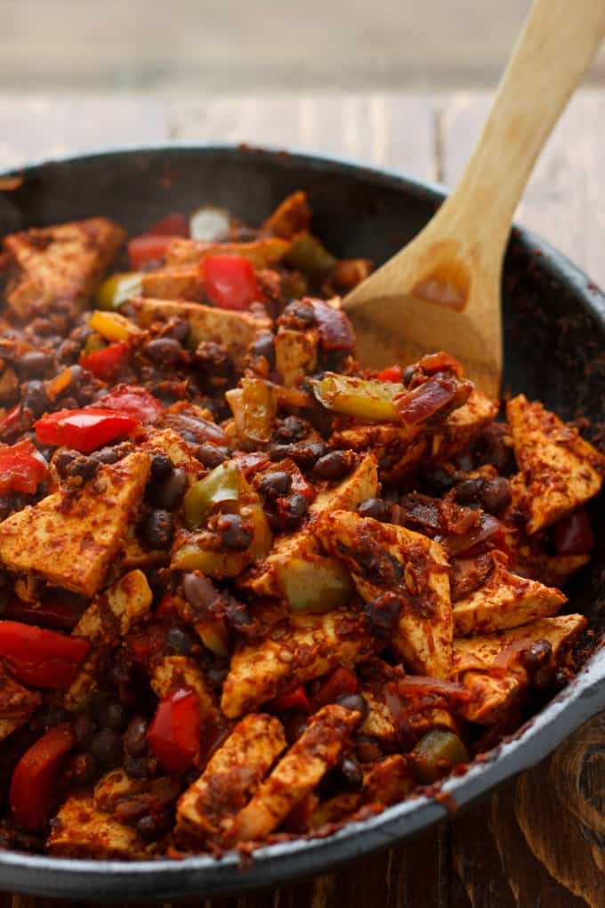 Spicy Tofu Quinoa in black pan with wooden spatula