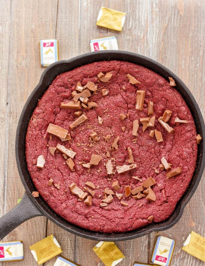 Cast Iron Giant Red Velvet Cookie Skillet in black pan on wooden table with candy spilled#redvelvet