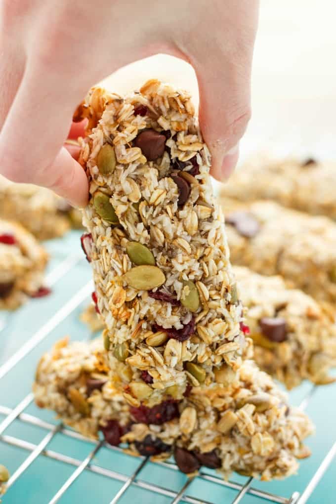 Banana granola bars on baking grid, one bar held by hand