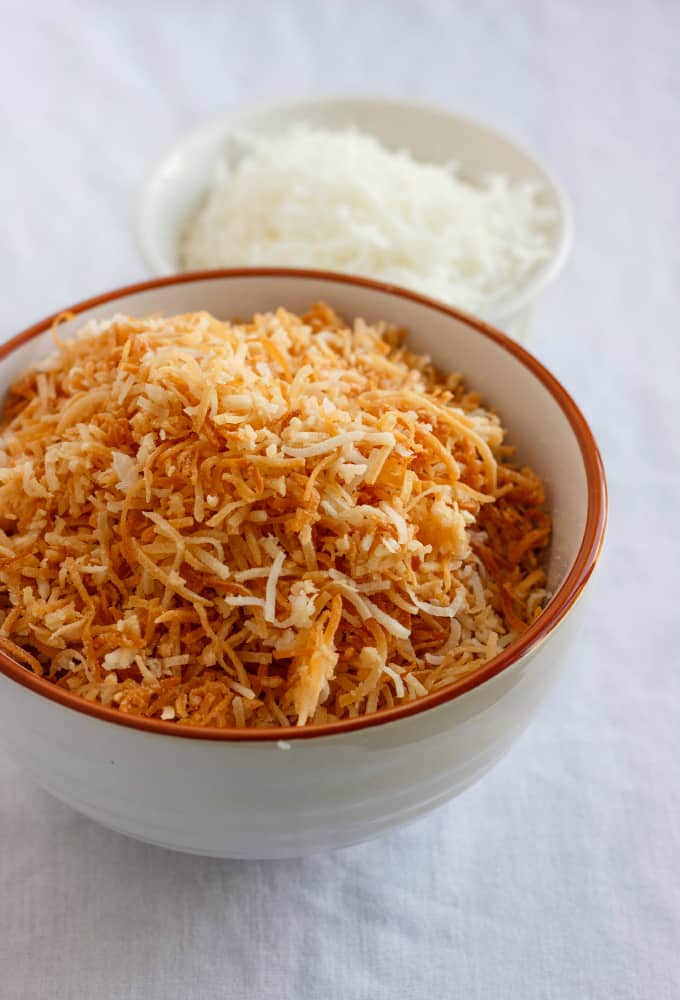 Toasted Coconut in orange and white bowl, non toasted coconut in white bowl