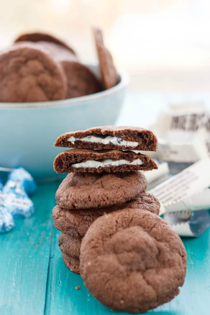 Pile ofCream Stuffed Cookies on table and in white bowl with candy around #cookies