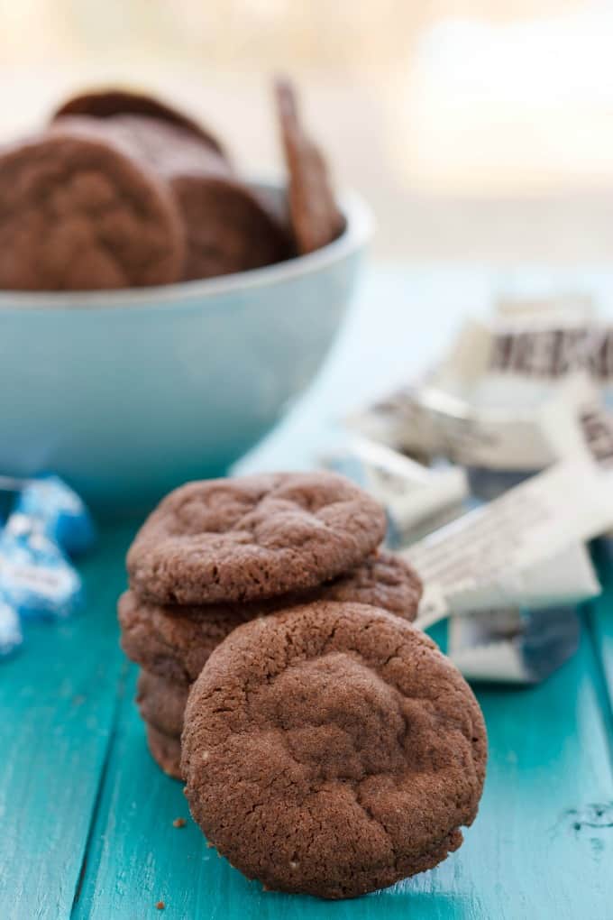  Pile of Cream Stuffed Cookies on blue table with white bowl and spilled candy