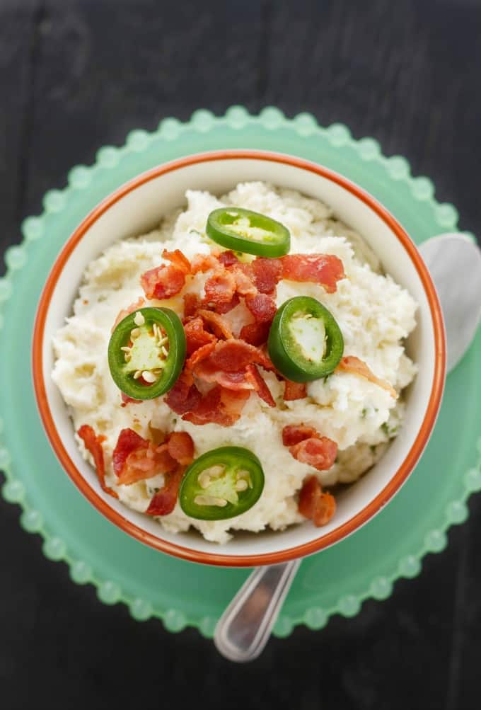 Jalapeno Popper Mashed Potatoes in white bowl with spoon on green tray#glutenfree