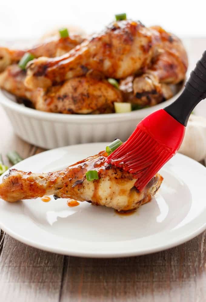 Honey Garlic Chicken Drumsticks in white bowl and on white plate with red brush