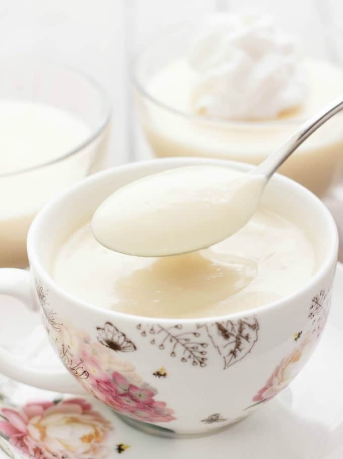 Homemade vanilla pudding in bowls with spoon and whiiped cream