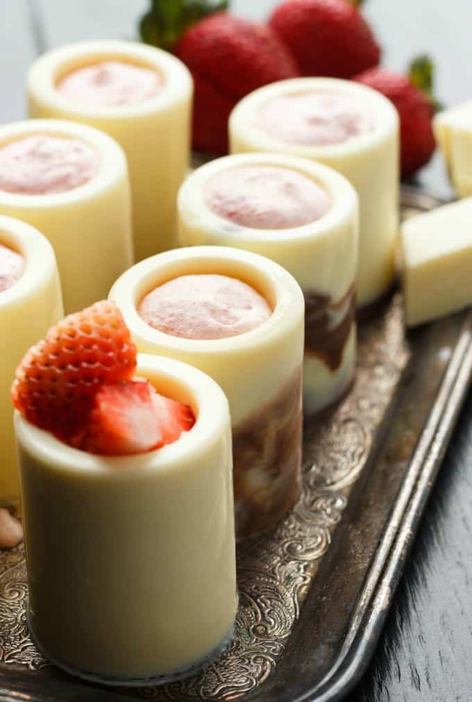 White Chocolate Shot Glasses with Strawberry Mousse on brown tray with ripe strawberries in the background #dessert