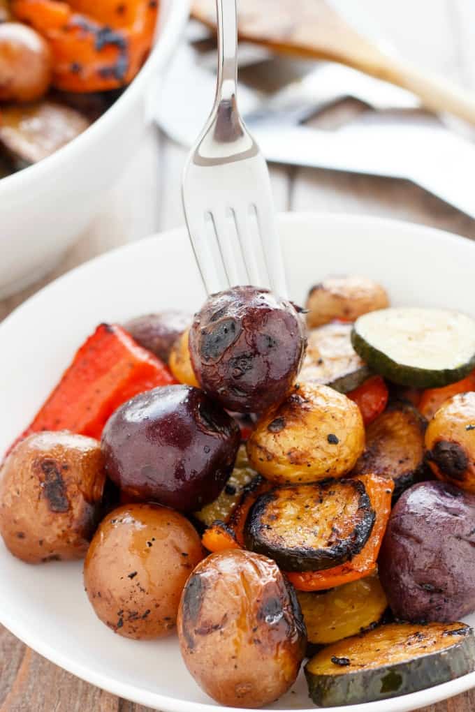 BBQ Potatoes and Vegetable Medley on white plate picked by fork #vegan