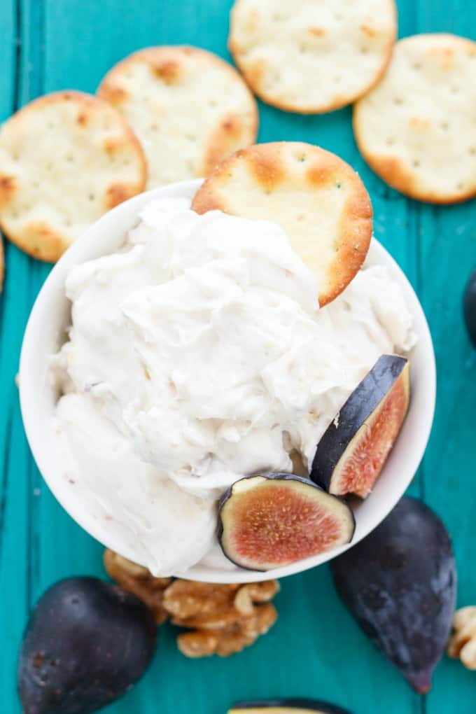 Farm Boy Fig and Walnut Cream Cheese Dip in white bowl on blue table with figs, walnuts and crackers