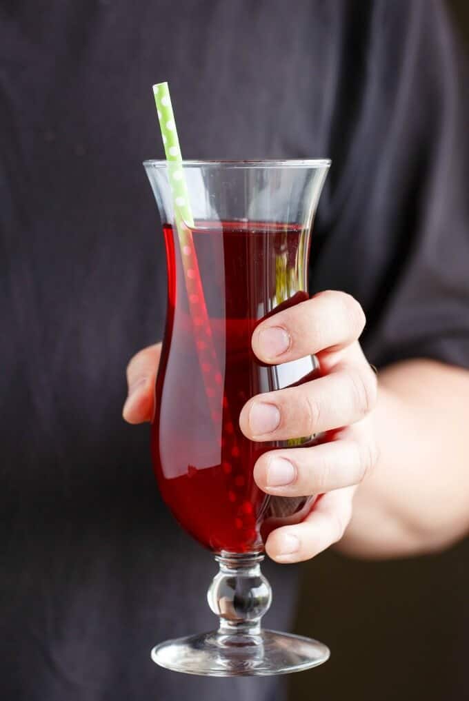 The Executionerdrink in glass cup wtih straw held by human