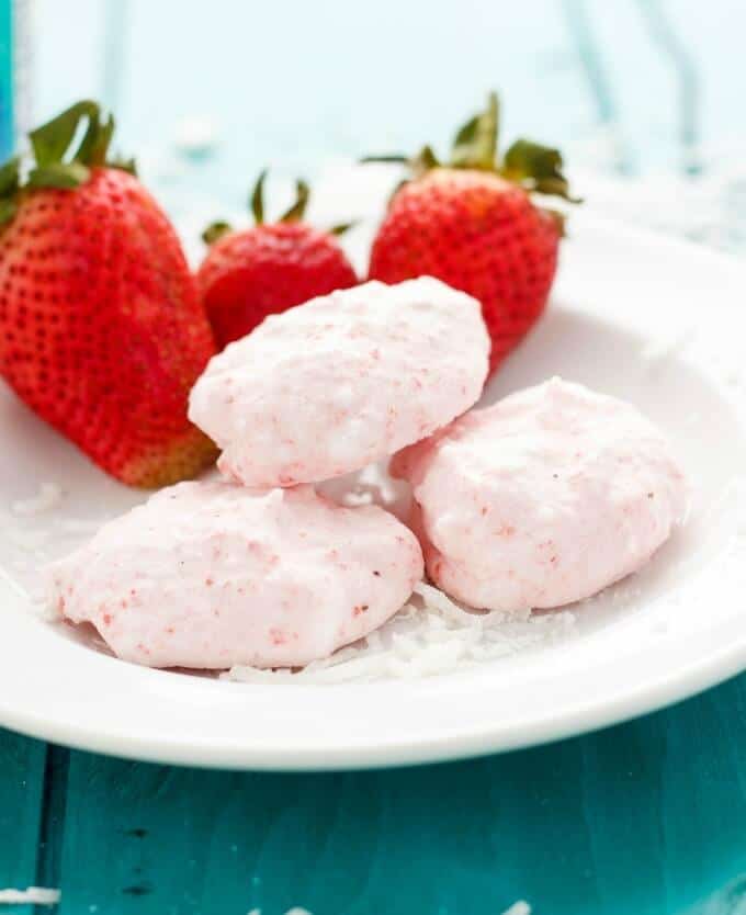 Three Ingredient Strawberry Frozen Bites on white plate with ripe strawberries