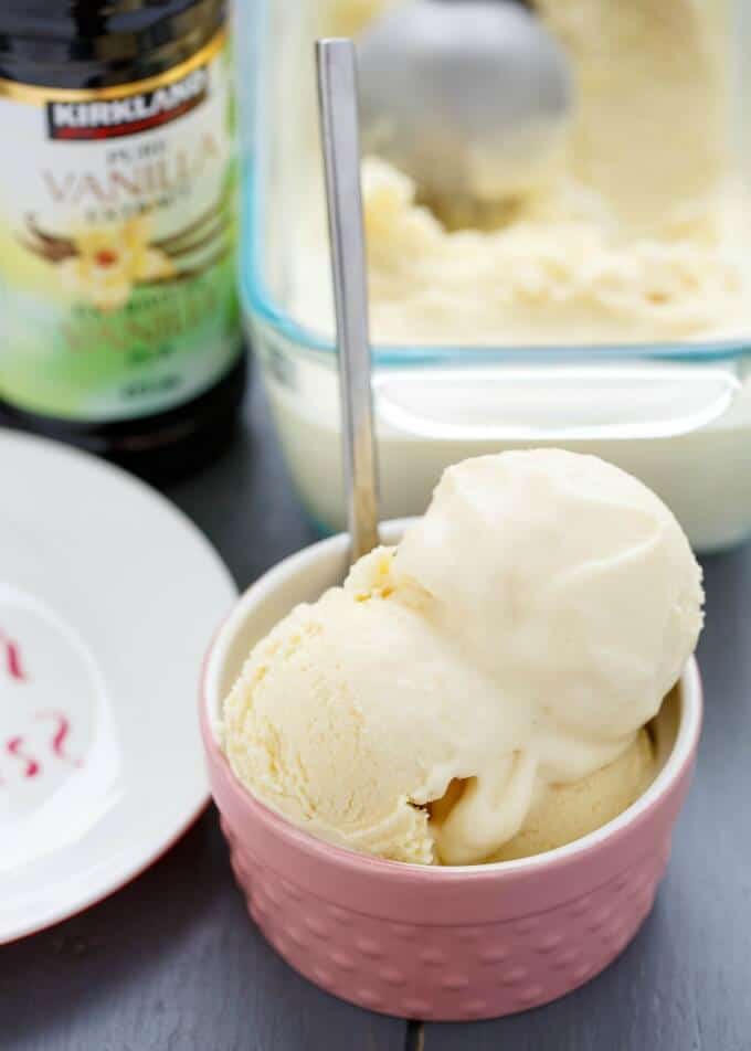 Basic Vanilla Ice Cream  in pink bowl with spoon on gray table with white plate and glass container