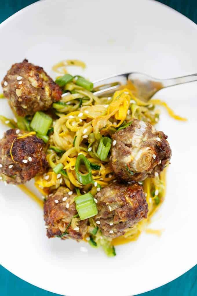 Miso Meatballs over Sauteed Zucchini Noodles on white plate with fork