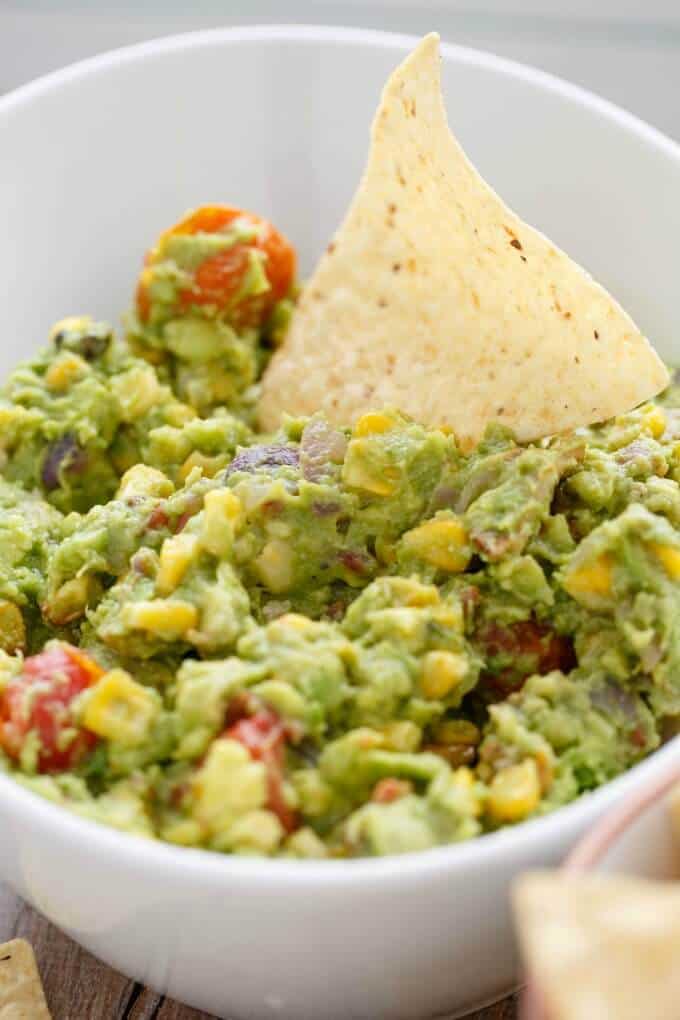 Roasted Guacamole with Bacon with chip in white bowl
