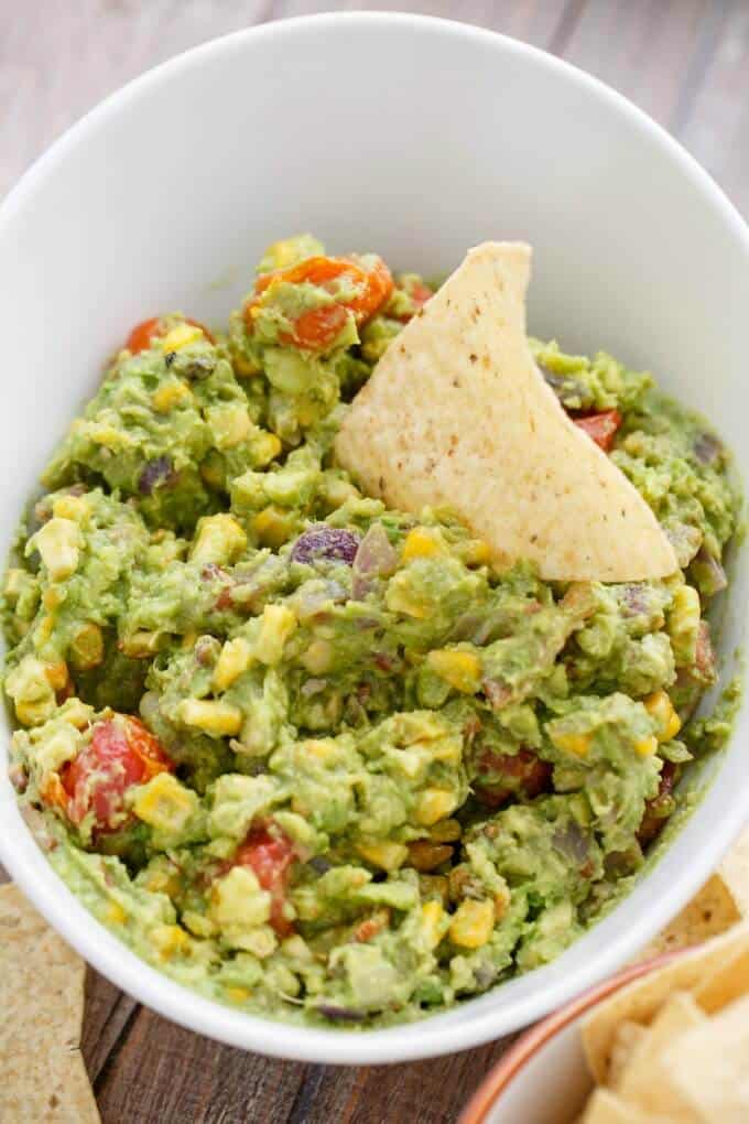 Roasted Guacamole with Bacon with chip in white bowl